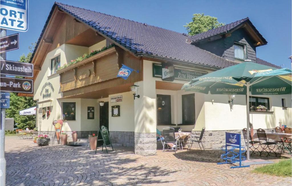 a building with chairs and umbrellas in front of it at Pet Friendly Apartment in Carlsfeld