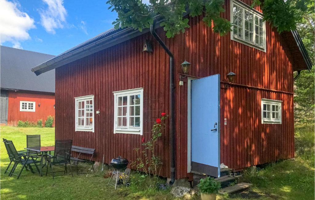 eine rote Scheune mit einem Tisch und Stühlen in der Unterkunft 2 Bedroom Awesome Home In Vstervik in Västervik