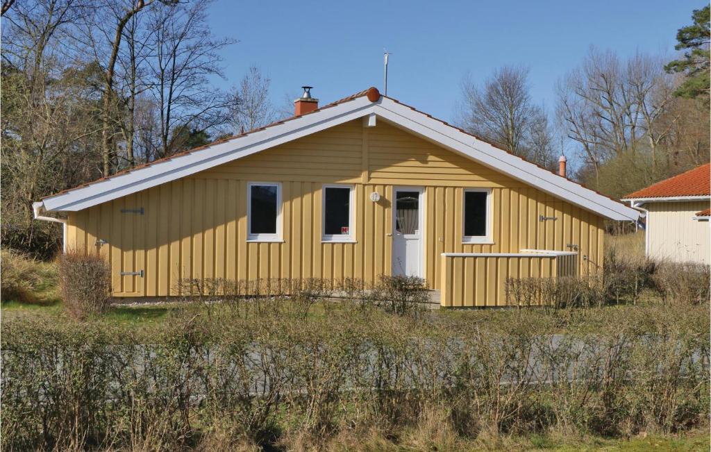 una casa gialla con una porta bianca in un campo di Morgensonne 2 - Dorf 2 a Priwall