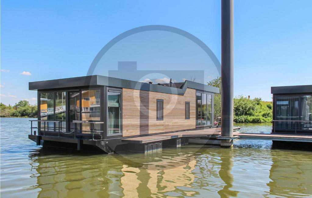 a floating house on the water with a glass dome at Houseboat Waterlelie in Ohé en Laak