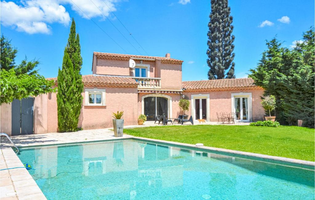 a villa with a swimming pool in front of a house at Gorgeous Home In Eyguieres With Outdoor Swimming Pool in Eyguières