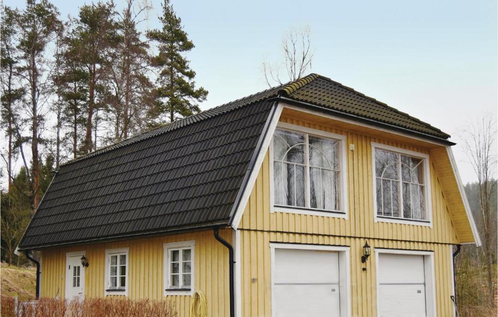 a yellow house with a black roof and two windows at Awesome Apartment In Sunne With 1 Bedrooms And Wifi in Östra Ämtervik