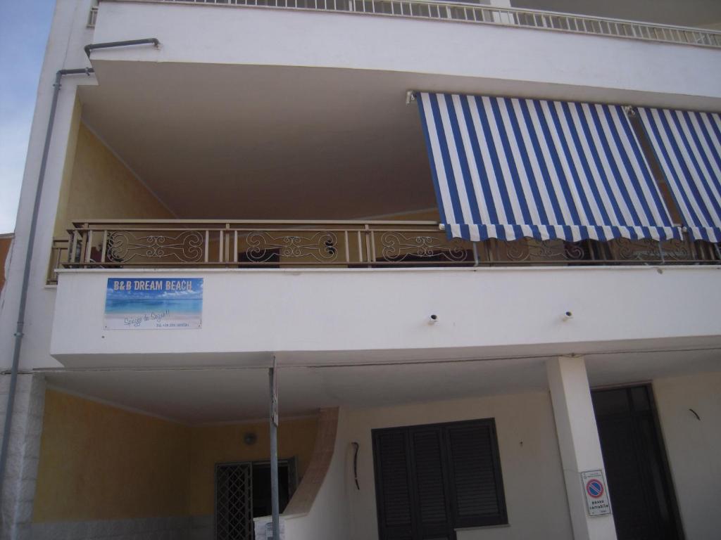 a balcony on the side of a building with a flag at Dream Beach Salento in Porto Cesareo