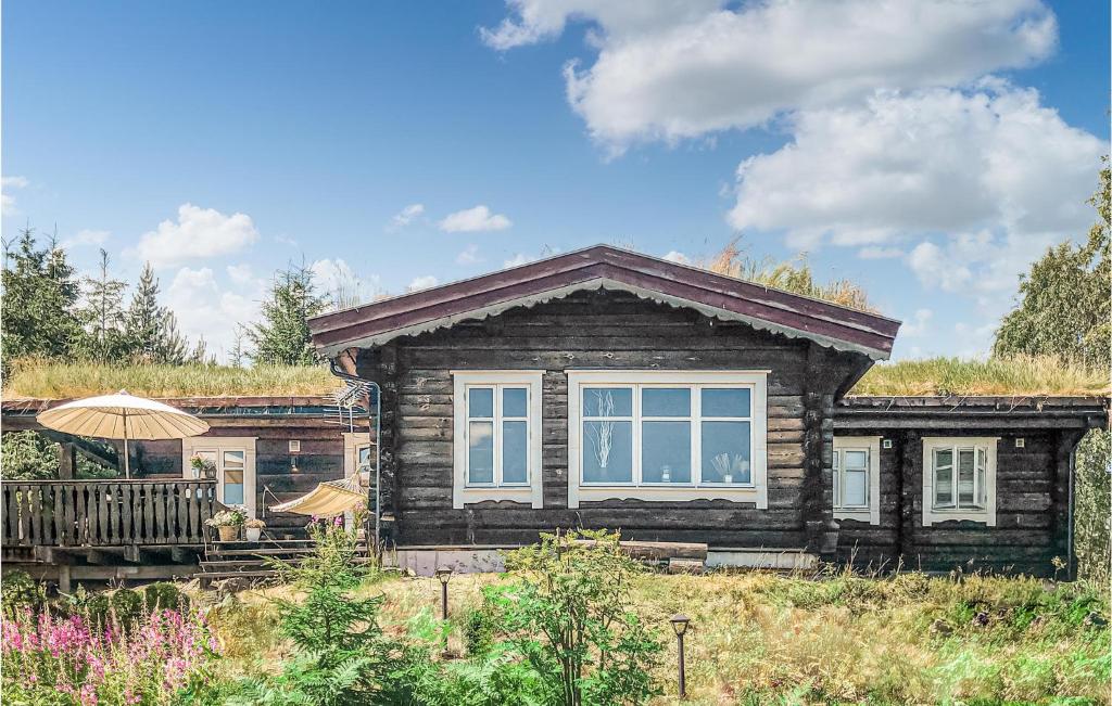 une maison en bois avec un parasol devant elle dans l'établissement 4 Bedroom Beautiful Home In Svarstad, à Svarstad