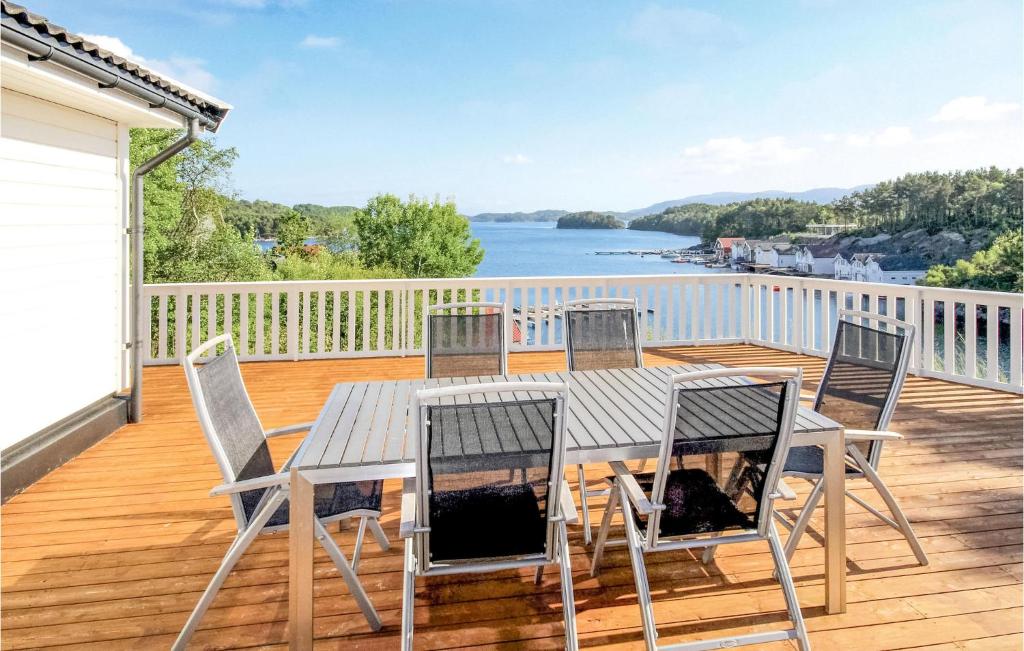 VestvikにあるAmazing Home In Auklandshamn With 4 Bedrooms, Wifi And Indoor Swimming Poolのテーブルと椅子が備わるデッキから水辺の景色を望めます。