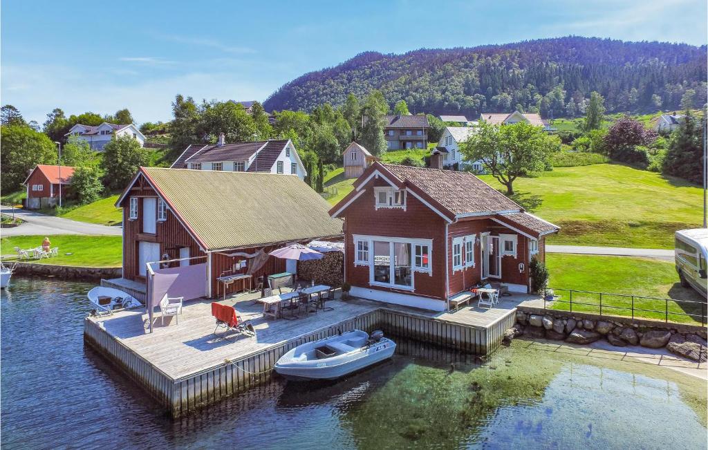 a house on the water with a boat on a dock at Amazing Home In Erfjord With 3 Bedrooms And Wifi in Erfjord