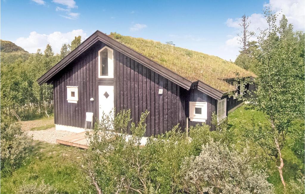 un edificio blanco y negro con techo de hierba en Cozy Home In Gl With Sauna en Gålå