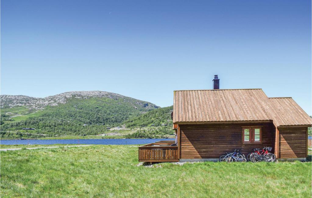 a log cabin with bikes parked outside of it at Cozy Home In Vikes With House A Mountain View in Vikeså