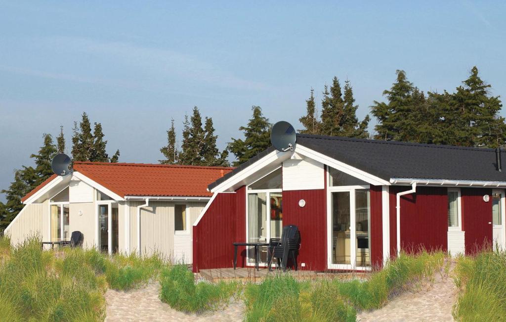 ein rotes und weißes Haus am Strand in der Unterkunft Freibeuterweg 23 - Dorf 5 in Travemünde