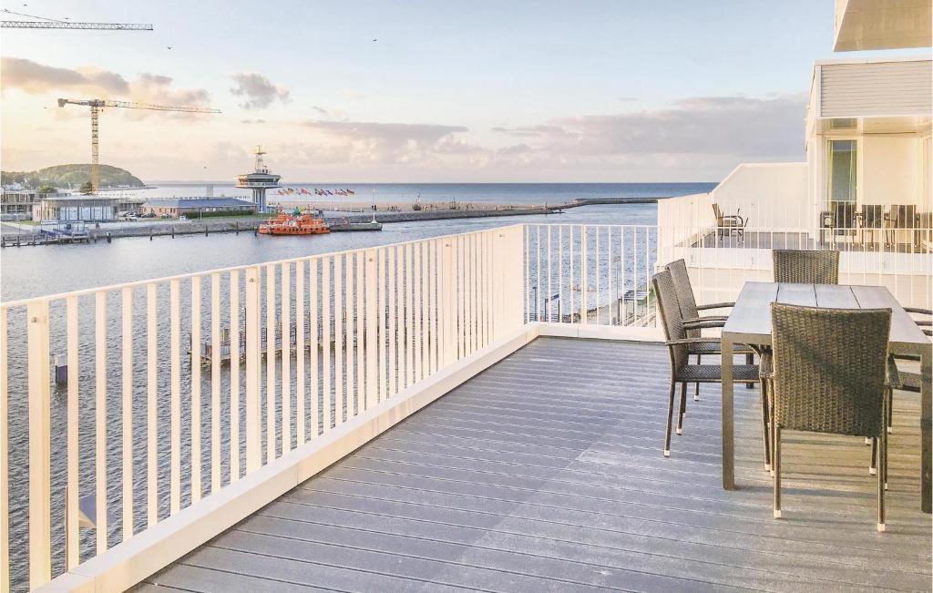 uma varanda com uma mesa e cadeiras e o oceano em Promenadenvilla em Priwall