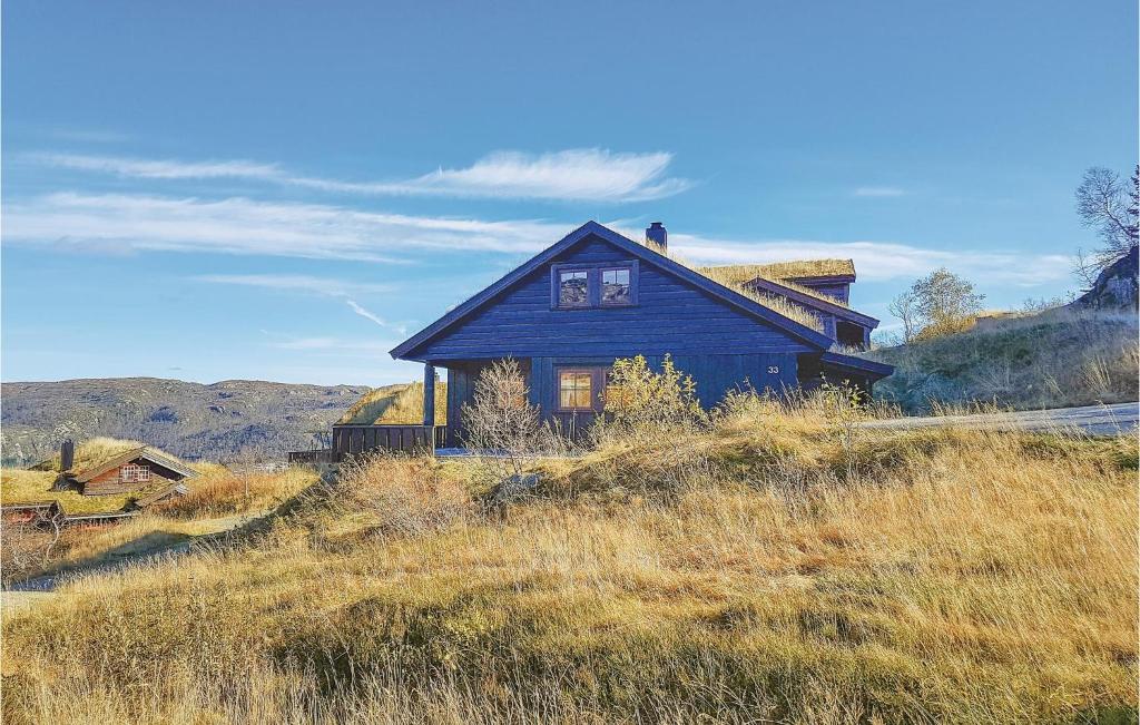 a blue house sitting on top of a hill at Lovely Home In seral With House A Mountain View in Ljosland