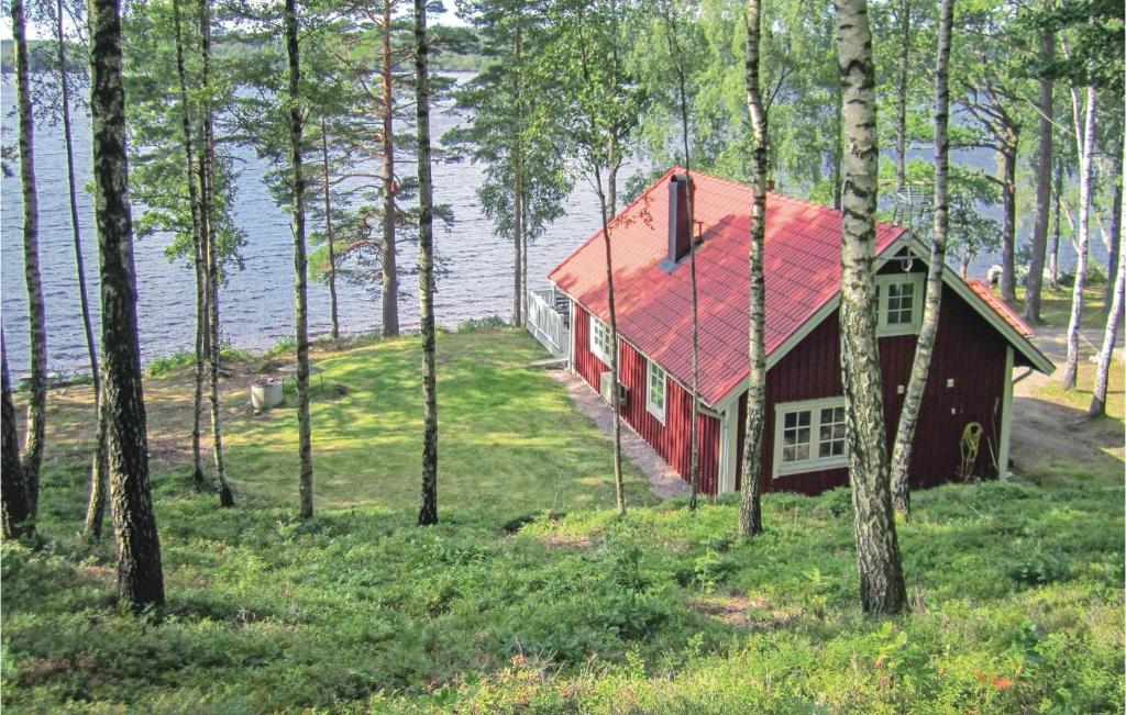 a red house with a red roof in the woods at Awesome Home In Hyltebruk With Sauna in Hyltebruk