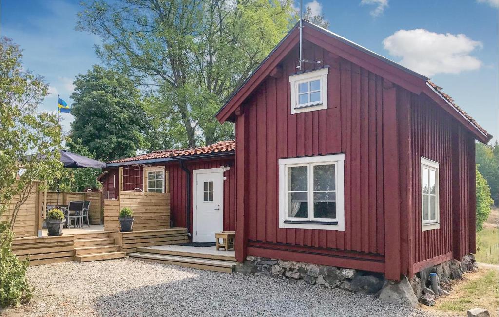 uma casa vermelha com uma porta branca e um alpendre em Gorgeous Home In Tystberga With Kitchen em Tystberga