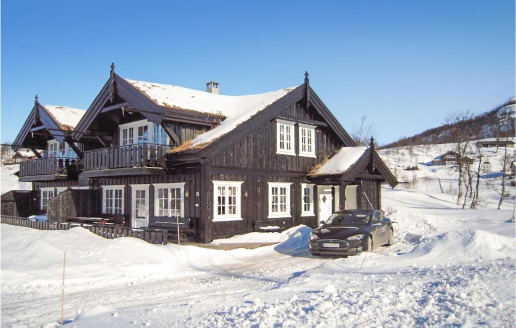 a house with a car parked in the snow at Amazing Home In Rauland With 4 Bedrooms And Sauna in Rauland