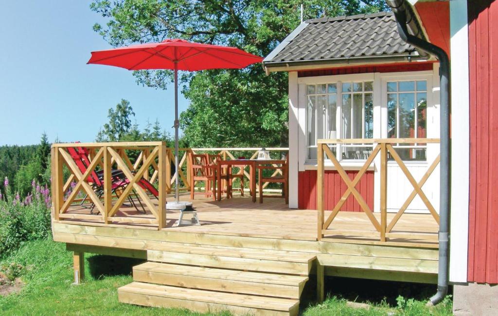 a wooden deck with a table and an umbrella at 2 Bedroom Gorgeous Home In Bodafors in Bodafors