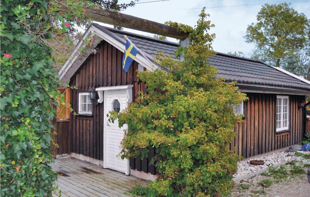 una pequeña casa de madera con una bandera. en Gorgeous Home In Lrbro With Kitchen en Lärbro