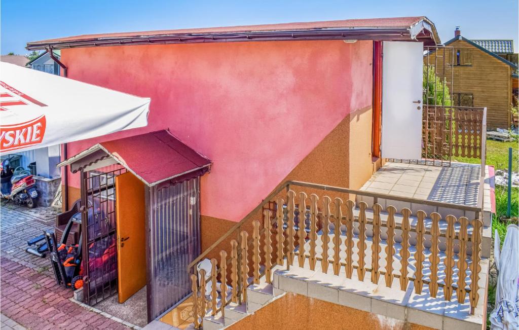 a house with a staircase next to a building at Awesome Home In Dzwirzyno With House A Panoramic View in Dźwirzyno