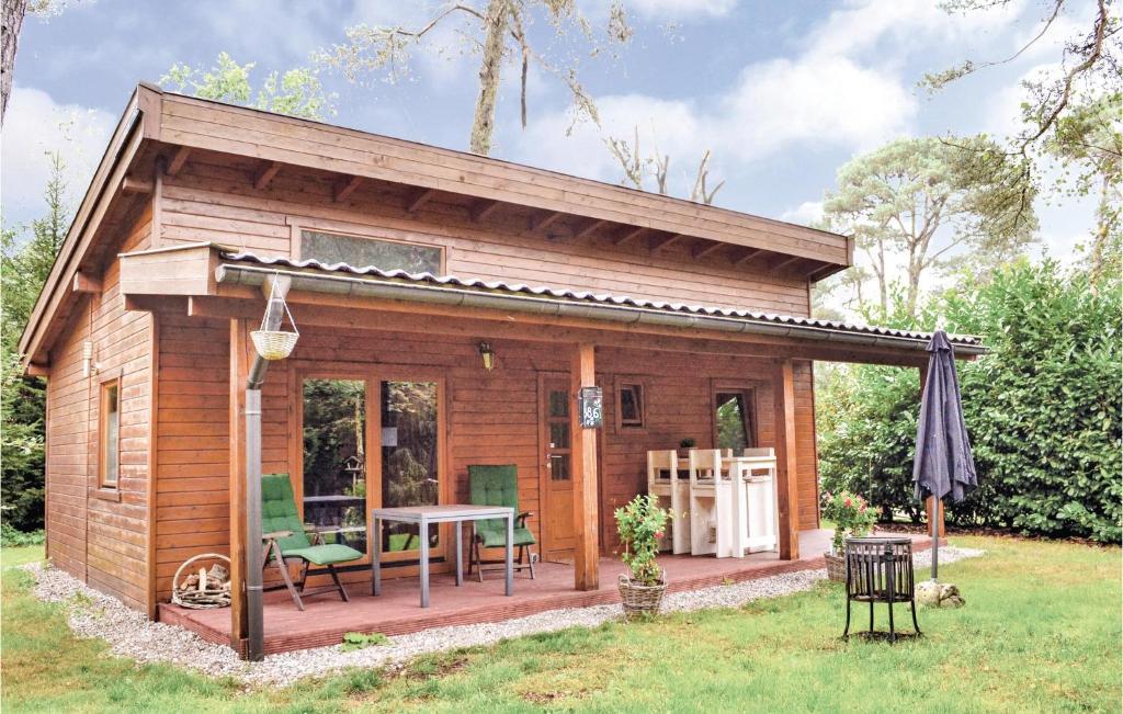 a small wooden cabin with a table in a yard at Boshuisje Veluwe - De Tjiftjaf in Emst