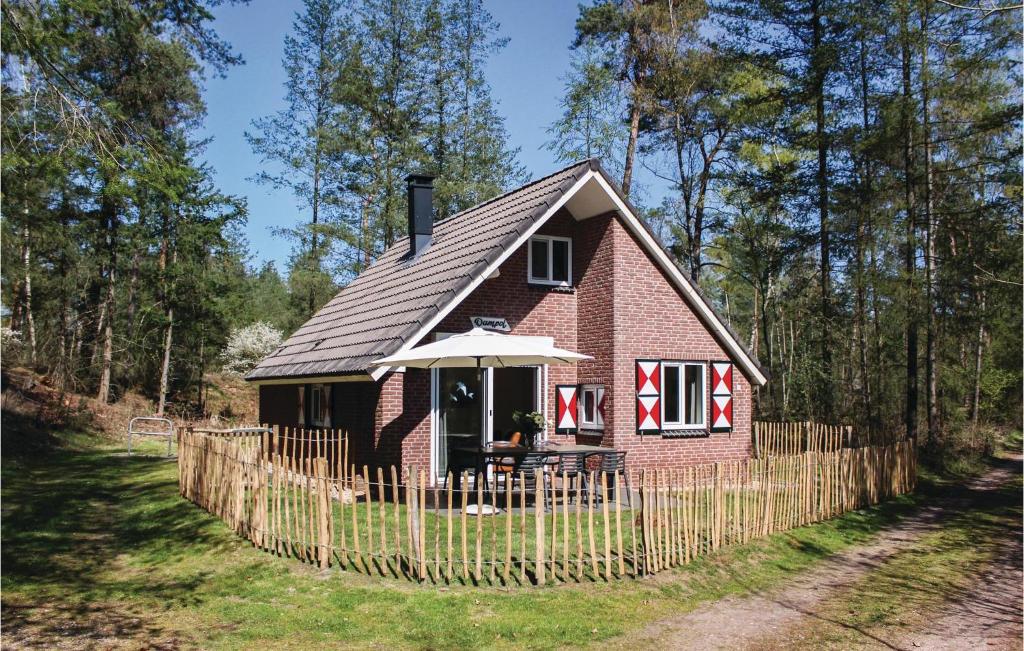 een klein rood bakstenen huis met een hek bij Dampol in Ommen