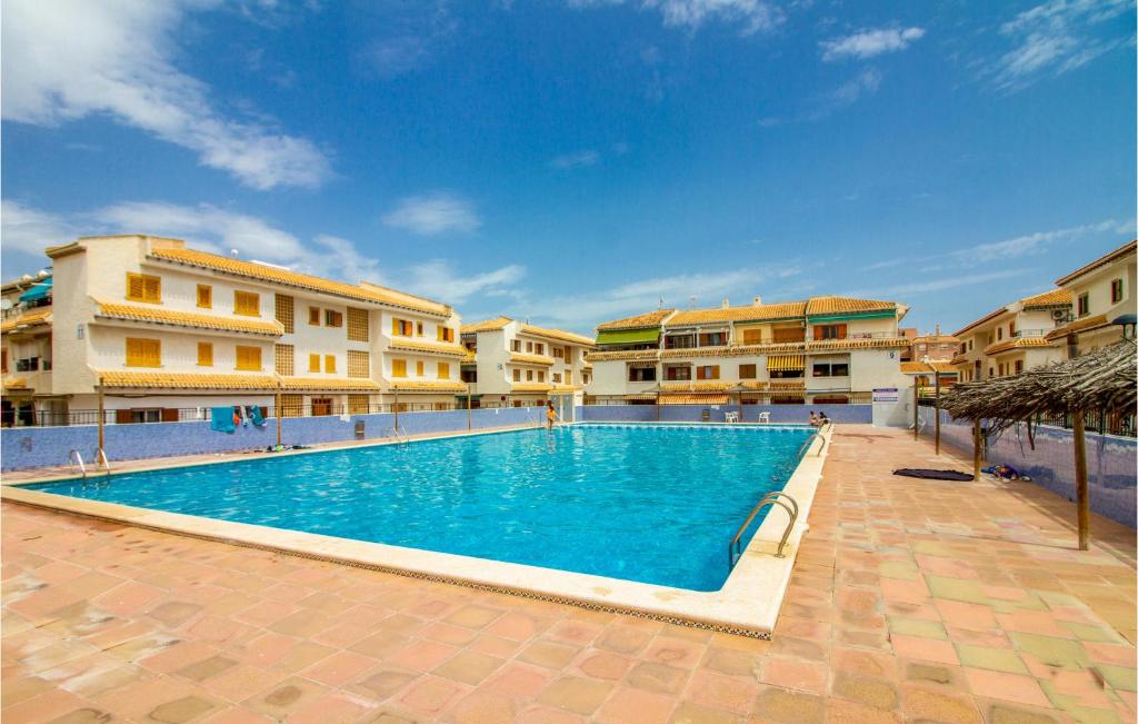 ein Pool vor einigen Apartmentgebäuden in der Unterkunft Nice Apartment In Santa Pola With Swimming Pool in Santa Pola