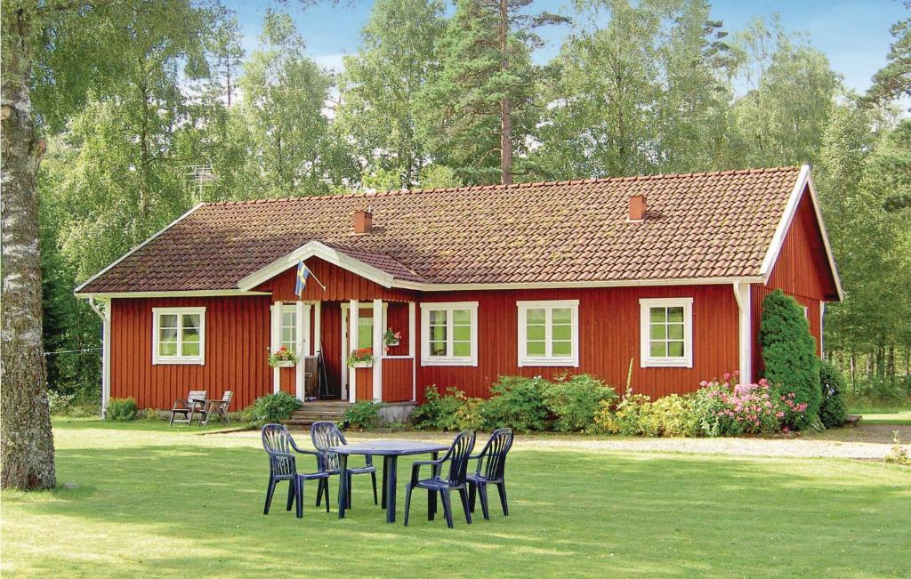 una casa roja con una mesa y sillas frente a ella en Pet Friendly Home In Torup With Kitchen en Hallaböke