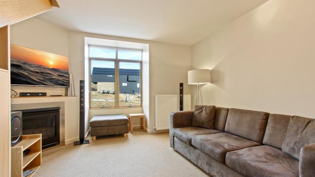 a living room with a couch and a fireplace at Chalet Hotham 20 in Mount Hotham