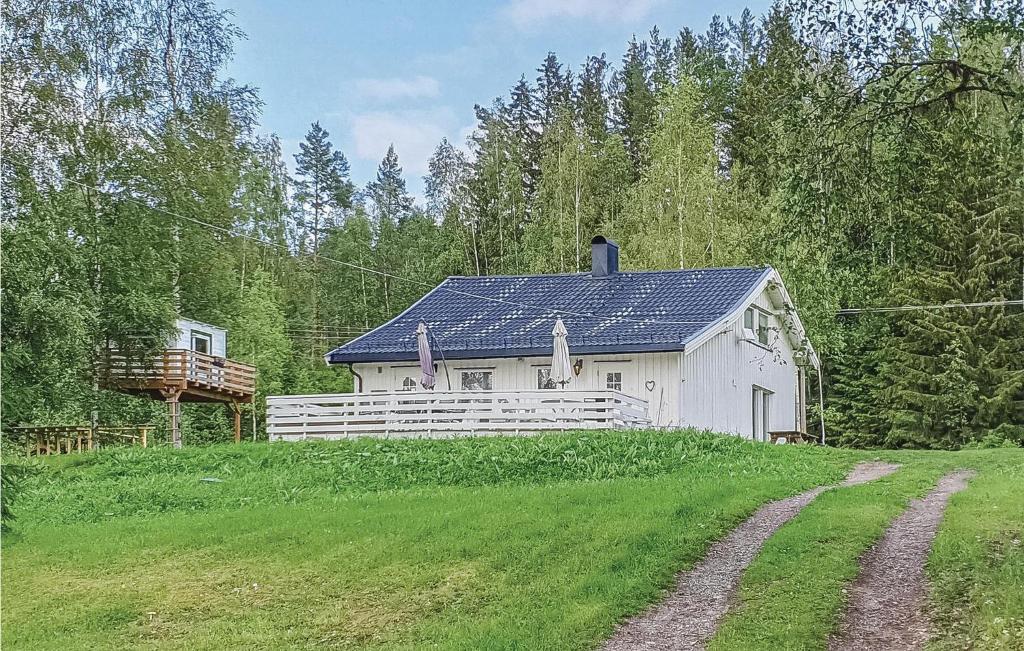 un fienile bianco con un tetto solare in un campo di 3 Bedroom Cozy Home In Aurskog a Urskog