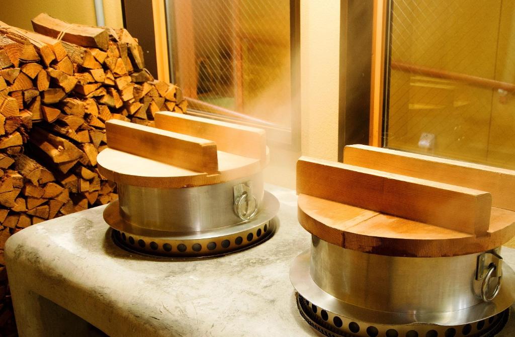 a grinding machine sitting on a counter next to a pile of wood at Suihoen in Gero