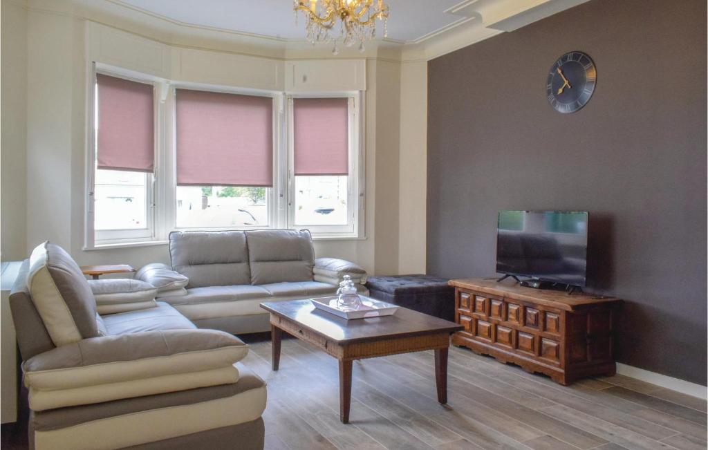 uma sala de estar com um sofá e uma televisão em Vwa De Panne em Adinkerke