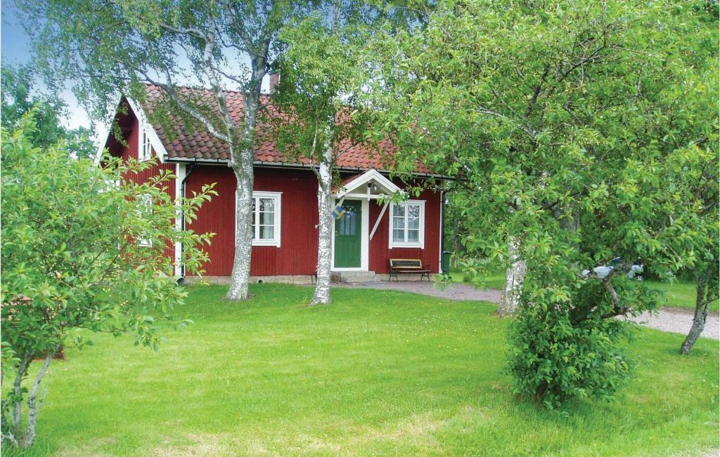 una casa roja con césped delante en 3 Bedroom Beautiful Home In Lundsbrunn, en Lundsbrunn