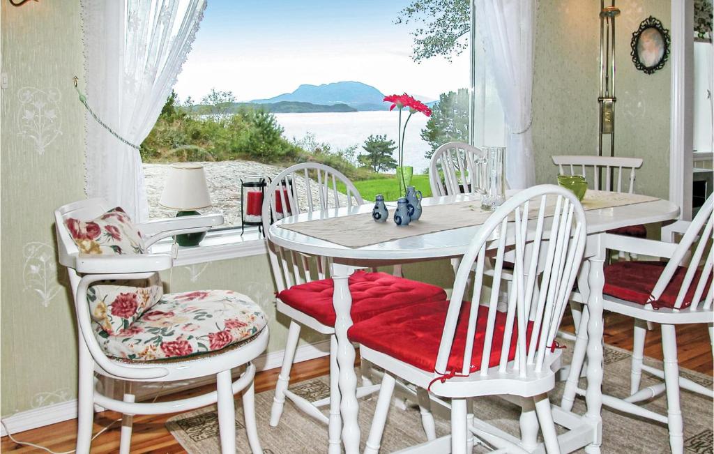 comedor con mesa, sillas y ventana en Nice Home In Etne With House Sea View, en Børkjenes