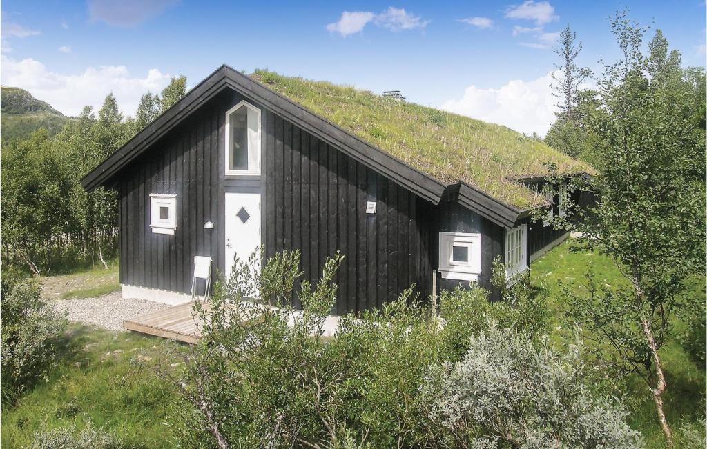 ein schwarzweißes Gebäude mit Grasdach in der Unterkunft Awesome Home In Gl With House A Mountain View in Gålå