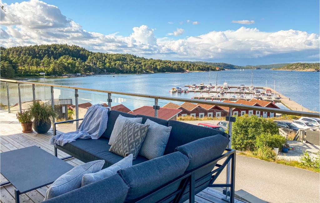 a blue couch on a balcony with a view of a river at Amazing Apartment In Svanesund With Kitchen in Svanesund