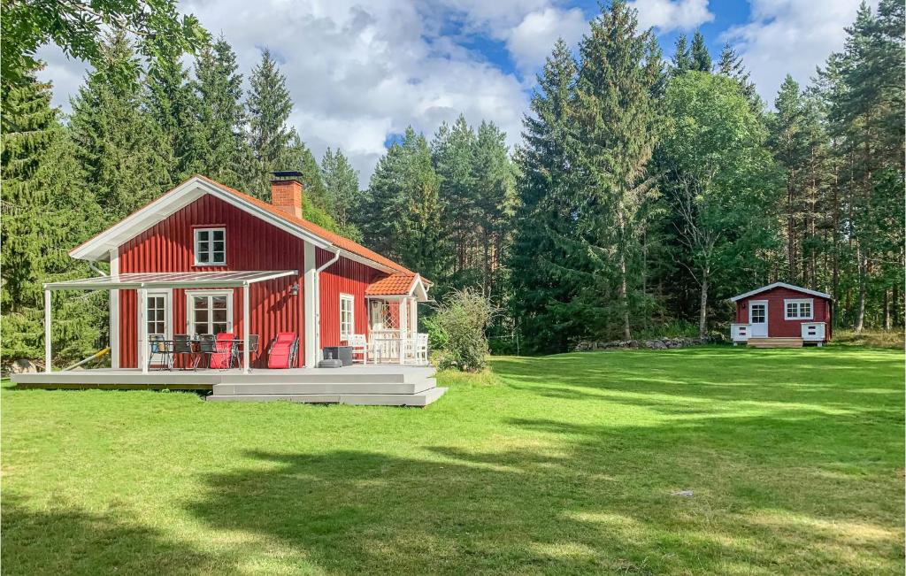 a red house in the middle of a grass field at Stunning Home In Vstervik With Kitchen in Västervik