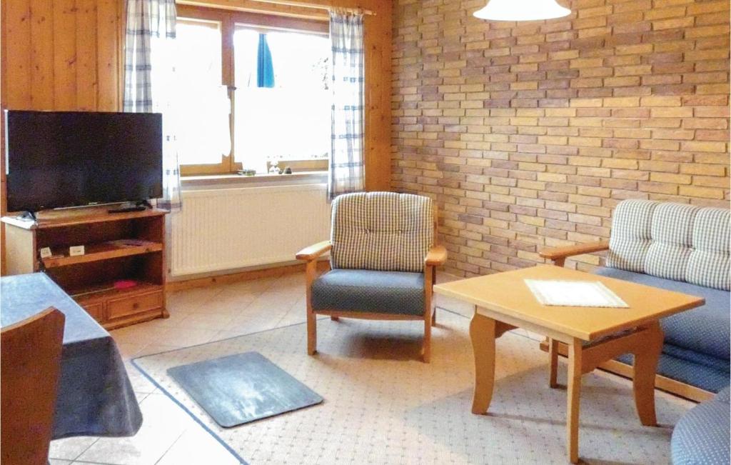 a living room with a couch and a tv at Cozy Apartment In Grfendorf With House A Panoramic View in Gräfendorf