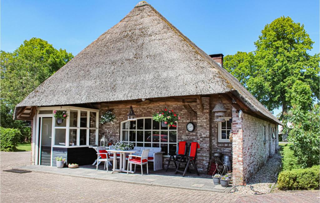 Ce cottage au toit de chaume dispose d'une table et de chaises. dans l'établissement 1 Bedroom Cozy Home In Udenhout, à Udenhout