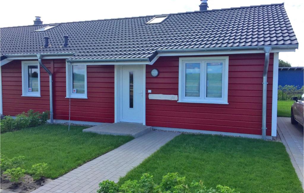 una casa roja con una puerta blanca en Beautiful Home In Dagebll With 1 Bedrooms And Wifi, en Dagebüll