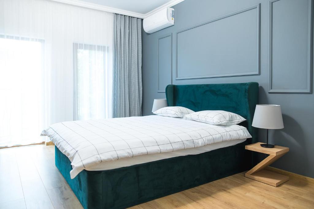 um quarto com uma cama com uma cabeceira verde em Deluxe Central Rooms em Karlovo
