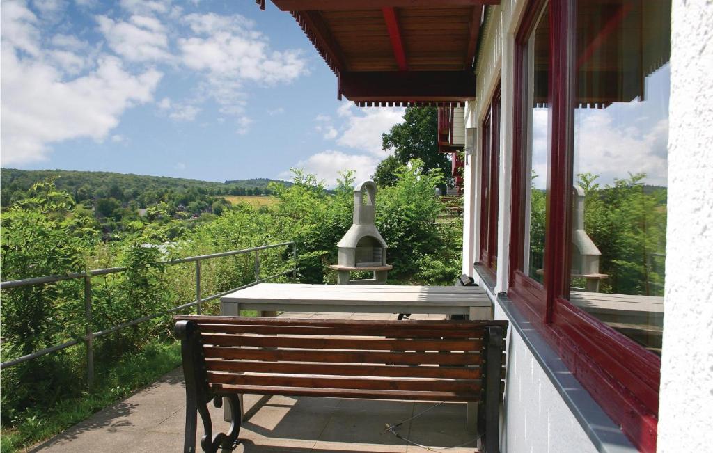 un banco sentado en el porche de una casa en Ferienhaus 44 In Kirchheim, en Kemmerode