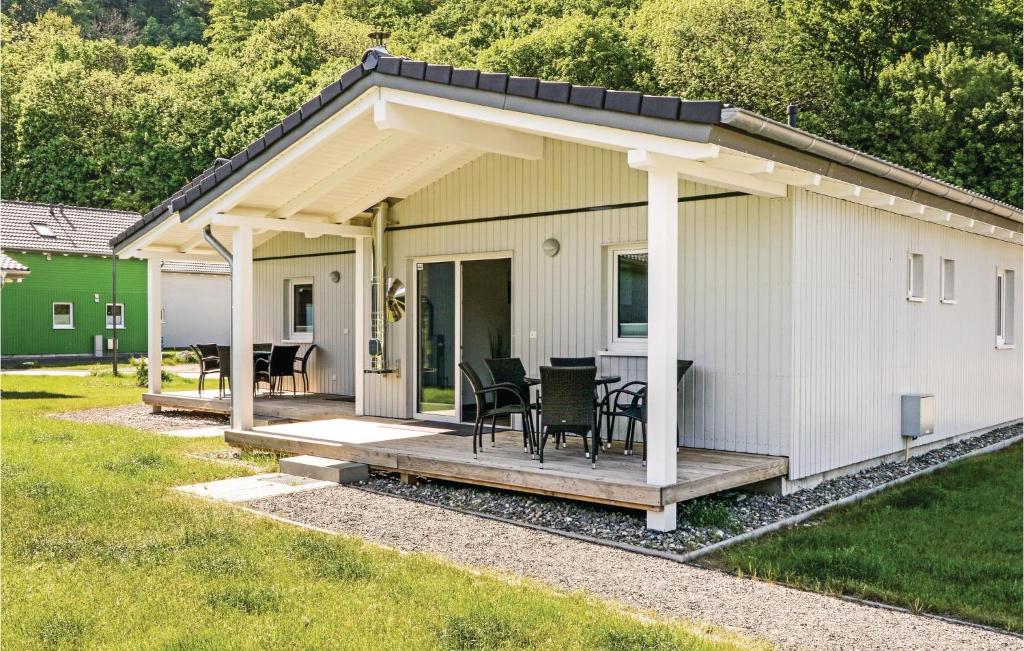 a small white house with a porch and chairs at Ferienhausdorf Thale in Thale