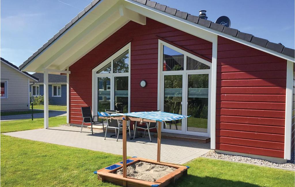 ein rotes Haus mit einem Tisch davor in der Unterkunft Nice Home In Dagebll With 2 Bedrooms, Sauna And Wifi in Dagebüll