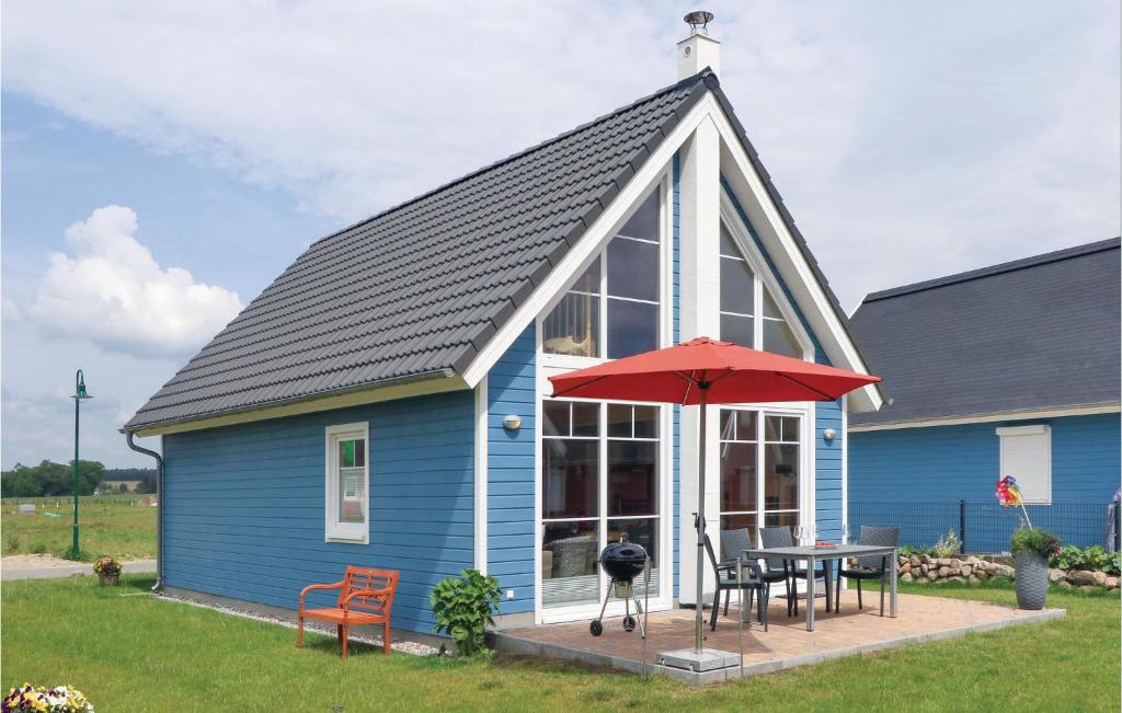 a blue house with a table and a red umbrella at Annes Bootshaus Hafenblick in Berg