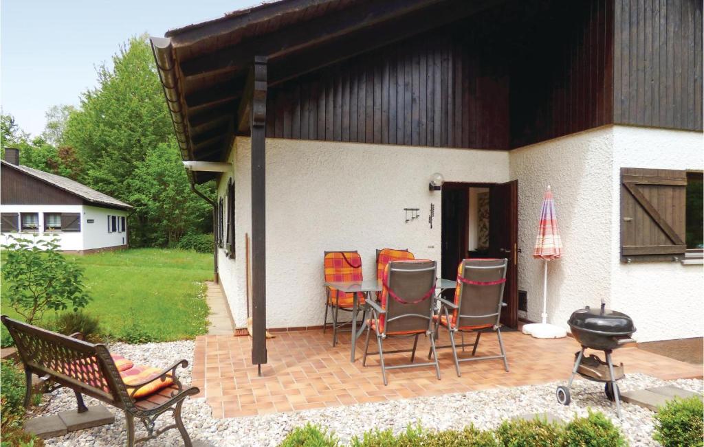 a patio with chairs and a grill next to a house at Ferienhaus 12 In Thalfang in Thalfang