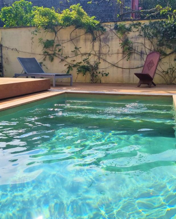deux chaises assises à côté d'une piscine dans l'établissement La Maison Bastide, à Bordeaux