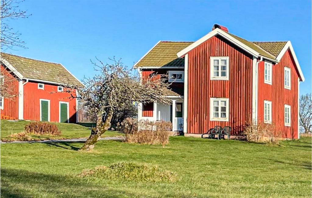 a red house and a red barn in a field at Gorgeous Home In Bodafors With Kitchen in Bodafors