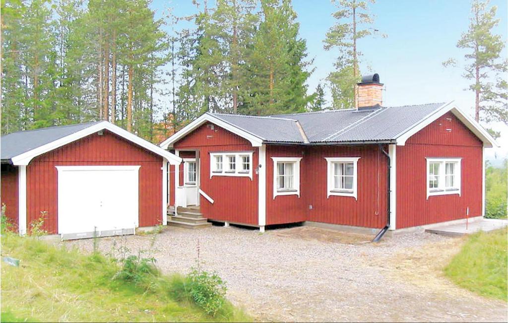 una casa roja con un garaje blanco en 3 Bedroom Awesome Home In Srna, en Särna