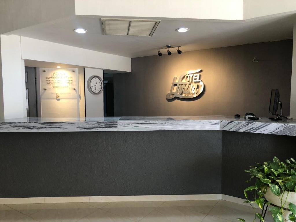 a bar in a restaurant with a sign on the wall at Hotel Lorena in Los Mochis