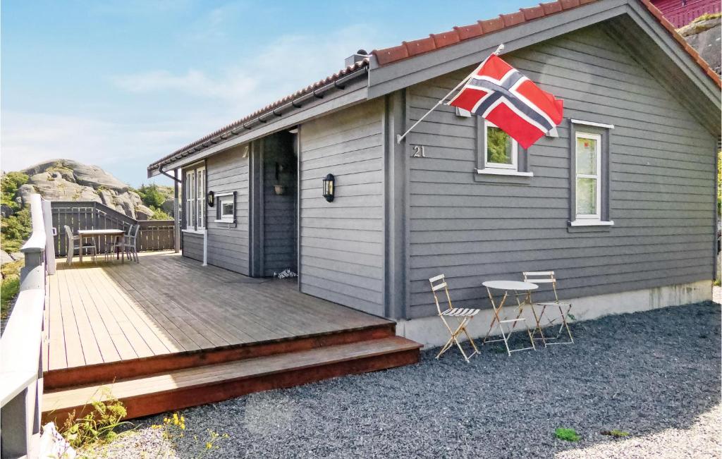 una casa con una terraza de madera con una bandera. en Beautiful Home In Hauge I Dalane With Kitchen, en Årstad