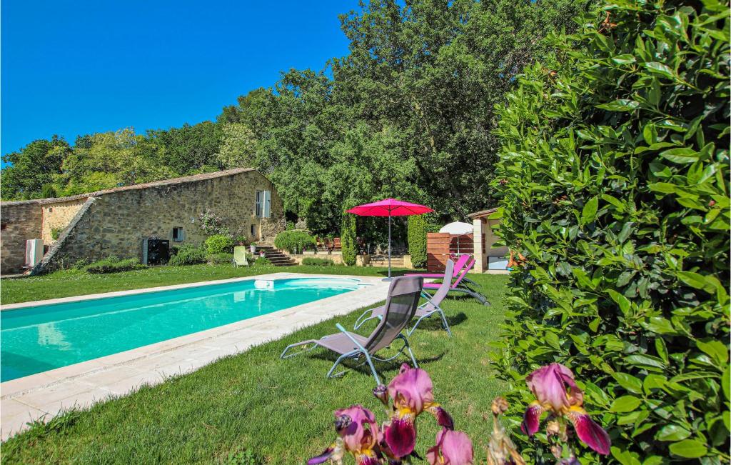 a pool with two chairs and an umbrella next to a house at Amazing Home In Bonlieu Sur Roubion in Bonlieu-sur-Roubion
