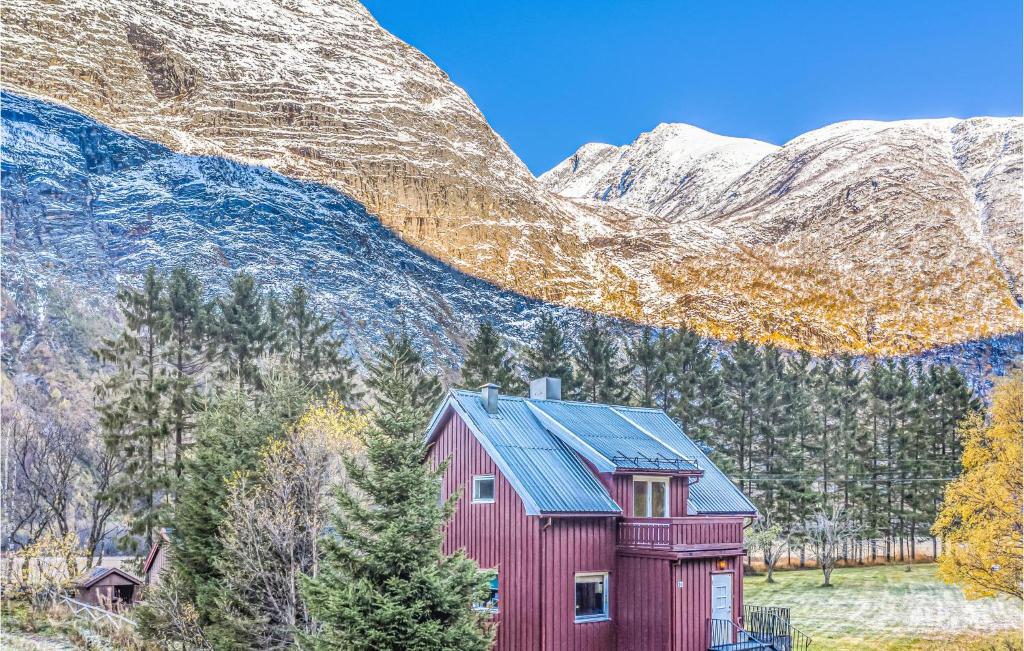 a red house with mountains in the background at Nice Home In Gjra With 2 Bedrooms And Wifi in Musgjerd